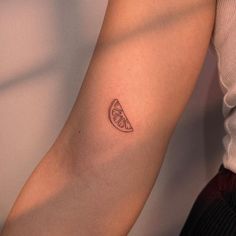 a small slice of fruit tattoo on the arm