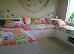 two beds with colorful comforters in a bedroom