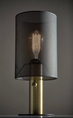 a lamp that is sitting on top of a table with a light in the middle