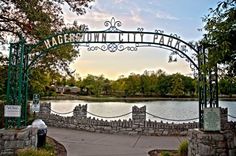 an entrance to a park with a lake in the background