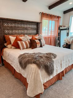 a bedroom with a large bed covered in blankets and pillows