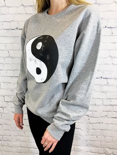 About -Oversized -50% Cotton 50% Polyester -Hand Wash -Crewneck Pullover -Distressed Ying Yang Graphic It's time to pull out your 90's nostalgia out of the back of the closet. We are in love with this oversized crew neck sweatshirt with a distressed ying-yang graphic at the front. We love this paired with a pair of bike shorts or leggings for a casual style for any day of the week. Hip Hop Distressed Crew Neck Top, Distressed Hip Hop Crew Neck Top, Distressed Crew Neck Sweater For Streetwear, Trendy Distressed Long Sleeve Sweatshirt, Trendy Distressed Long-sleeve Sweatshirt, Trendy Long Sleeve Distressed Sweatshirt, Distressed Long Sleeve Sporty Sweatshirt, Sporty Long Sleeve Distressed Sweatshirt, Distressed Grunge Crew Neck Sweatshirt