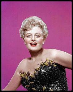 an old photo of a woman wearing a black dress with sequins on it