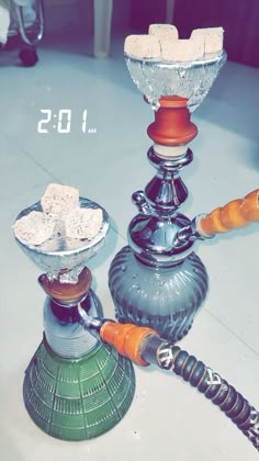 three glass candlesticks sitting on top of a table next to an orange pipe