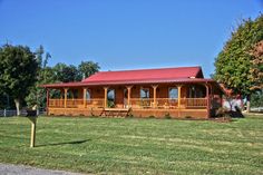 a large wooden house sitting on top of a lush green field