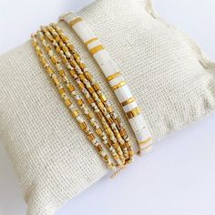 Beautiful set of two bracelets, a beaded strech wrap bracelet with lots of gold plated beads that gives the braclet a beautiful sparkle combined with an adjustable tila bracelet on silk cord. M A T E R I A L * Seed beads from Miyuki (high quality seed beads from Japan) gold plated (24 kt) and off white with brown/beige pattern * Very strong elastic * Silk cord * Tila beads, off white & gold ( 24 kt gold plated) * Gold plated sliding bead ( with rubber inside so the bracelet is adjustable) S Woven Bracelet Diy, Stretch Beaded Bracelets Diy, Tila Bracelets, Bracelets Dainty, Jewelry Stacking, Tila Beads, Loom Bracelet Patterns, Loom Bracelet, Beige Pattern