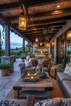 an outdoor living area with couches, tables and lamps