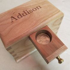 a wooden box with a penny in it and the word madison on it's side