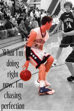 a young man dribbling a basketball while standing on a court with people watching