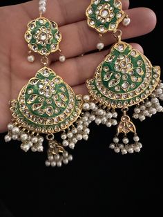 It's time you level up your jewelry box! Add in some extra ordinary piece in your collection! This majestic 22 KT gold plated lock thappa kundan chandbali earrings with beautiful combination of hand painted meena work and kundan pearl work earrings with sahara. In stock and ready to ship. Color : green Note :Color, shades, texture displayed may slightly vary from the actual product due to digital image limitations. We request you to consider these minor variations. Please expect the possibility Kundan Tilla Dangle Jewelry, Green Dangle Chandbalis For Festivals, Green Stone Work Chandbalis For Celebration, Green Kundan Chandbali Chandelier Earrings, Green Kundan Chandelier Earrings With Latkans, Traditional Kundan Earrings For Celebrations, Traditional Chandbali Jewelry With Mirror Work, Stone Work Bridal Earrings Gift For Eid, Stone Work Bridal Earrings For Eid