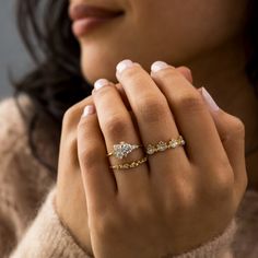 a close up of a woman's hand with a ring on her left hand