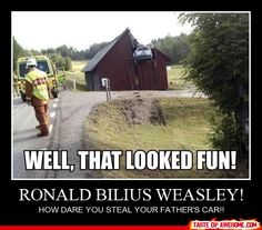 a man walking down a road next to a red barn with a car on it