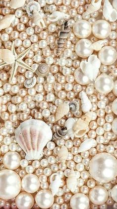 pearls, seashells and starfish are arranged in a pattern on the surface