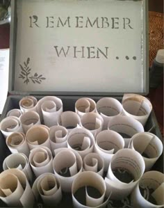 an open box filled with lots of white paper cups on top of a wooden table