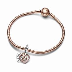 A jewelry gift for a mom who will always be perfect to you, just as she is. The Two-tone Infinity Heart Double Dangle Charm features an openwork heart dangle in 14k rose gold plating forming an infinity symbol in the center, adorned with a row of pink pavé and engraved with the word "Mom" with a pink stone as the central letter. Behind it is a sterling silver heart-shaped disc engraved with the message "To me you are perfect" creating a repeating pattern on both sides. Pink pavé on the bail adds a finishing touch. A celebration of motherly love in all its forms. Elegant Dangling Charms For Mother's Day, Heart-shaped Rose Gold Charm Jewelry, Heart Charm As Gift, Elegant Heart-shaped Dangling Charms, Elegant Dangle Charms For Valentine's Day, Heart Charms For Anniversary, Elegant Heart Shaped Dangling Charms, Dangling Charms Jewelry For Valentine's Anniversary, Valentine's Day Anniversary Jewelry With Dangling Charms