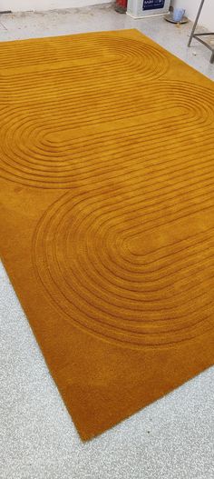 an orange area rug on the floor in a room with white walls and carpeting