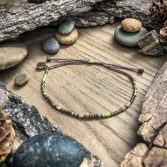 Celebrate Mother Nature with these rustic, earthy tones. Littering is for losers! Keep it clean :) Take only photos, leave only footprints when you're out there exploring.  This listing is for 1 adjustable seed bead bracelet on dark brownish, green cord with blue, greens, blues, tans, and bronze beads.  Each bracelet comes with a Colors of the Prairie logo charm/tag. - - - - - - - - - - - - - - -  ❂ 𝗦𝗜𝗭𝗘 ❂ Each bracelet adjusts between 5.5 - 10.5 inches (a standard size for this style). If y Bead And Wire Crafts, Leave Only Footprints, Earth Day Everyday, Adjustable Beaded Bracelet, Brownish Green, Sliding Knot Closure, Seed Bead Bracelet, Wire Crafts, String Bracelet