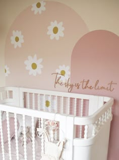 a white crib in front of a pink wall with daisies and the words they say, there is the limit