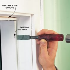 a person holding a tool in their right hand and pointing to the door with both hands