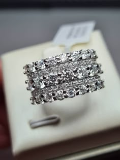 a pair of diamond rings sitting on top of a white box next to each other