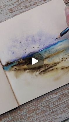 someone is drawing something with watercolors on paper