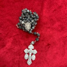 This handmade rosary features natural Black Labradorite stone beads and a silver coloured chain with a Pardon Crucifix and Miraculous Medal. Crafted with expert precision, this rosary is not only a beautiful spiritual tool, but also a stunning piece of jewellery. The beautiful natural materials make it perfect for prayer and meditation. This item will be exorcized and blessed by a Catholic priest using the Traditional Latin Rite, after being purchased, and before being dispatched to you. Silver Rosary With Round Beads For Meditation, Adjustable Silver Rosary For Meditation, Silver Spiritual Rosary Bracelet With Gemstone Beads, Silver Beaded Rosary For Meditation, Spiritual Silver Beads Rosary Gift, Silver Faceted Beads Rosary Cross, Silver Rosary With 8mm Beads For Healing, Spiritual Silver Rosary Bracelet With Natural Stones, Silver Spiritual Rosary Bracelet For Healing