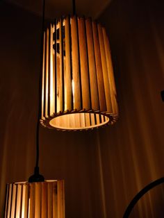 two wooden lamps hanging from the ceiling in a dimly lit room