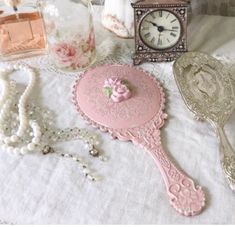 there are many items on the table including a clock, necklaces and other things