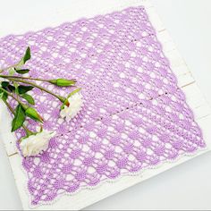 white flowers are placed on a purple doily