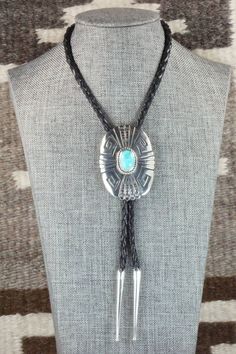 This turquoise and sterling silver bolo tie was made by Navajo silversmith Rosita Singer. The back is signed T&R Singer and stamped sterling.Tie Length: 22 1/4"Length: 2 3/8"Width: 1 3/4"Tips:Length: 2 1/8"Width: 1/4"Free shipping on all orders! We ship with USPS and always include tracking. All orders ship within a day of payment.Returns are accepted up to 30 days after you receive your order. Just send us a message. Our shop offers cash back or store credit. The item must be returned in new co Southwestern Adjustable Lariat Turquoise Necklace, Southwestern Lariat Turquoise Necklace, Southwestern Adjustable Turquoise Lariat Necklace, Adjustable Southwestern Turquoise Lariat Necklace, Adjustable Silver Lariat Necklace In Southwestern Style, Southwestern Turquoise Lariat Necklace, Western Blue Lariat Jewelry, Blue Lariat Western Style Jewelry, Blue Western Lariat Jewelry