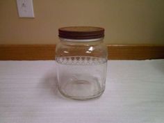 a glass jar sitting on top of a white tablecloth covered floor next to a light switch