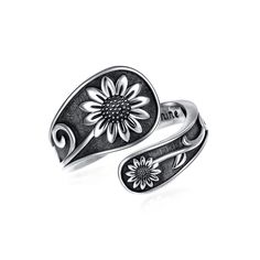 a silver ring with a flower on the front and an oval shaped band around it