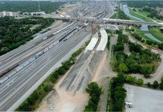 an aerial view of train tracks and freeways in the country side with trees on both sides