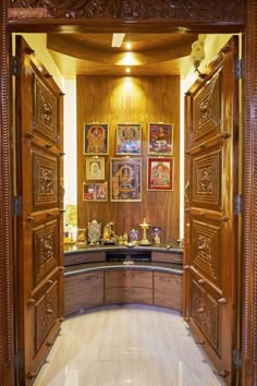 an open wooden door leading into a room with pictures on the wall