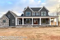 a large gray house sitting on top of a dirt field