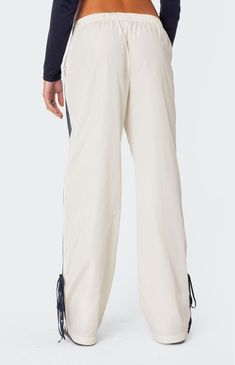 Online only! These track pants offer both style and comfort, making them perfect for a sporty yet fashionable look. They're ideal for any activity, ensuring you feel comfortable and confident throughout your entire day.


	Track pants
	Side stripe detailing
	Ribbon tie ankle detail
	Elastic waist
	Polyester
	Model wears size S
	Model height is 5'7
	Item care: Wash with similar color Visionary Fashion, Track Pants Women, Curve Jeans, Bow Ribbon, Ribbon Tie, Side Stripe, Pant Shirt, Short Rompers, Skirted Swimwear