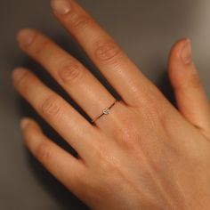 a woman's hand with a diamond ring on it