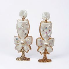 Introducing our glamorous Acrylic Champagne Glass Earrings, where elegance meets playful sophistication. Crafted with precision and attention to detail, these stunning earrings are designed to add a touch of luxury to any ensemble. Whether you're attending a soirée, a wedding reception, or simply want to elevate your everyday look with a hint of whimsy, these earrings are sure to turn heads and spark conversations. Lightweight yet impactful, they offer the perfect balance between style and comfort. Make a statement and toast to style with our Acrylic Champagne Glass Earrings. Cheers to sophistication, cheers to fun, and cheers to you! Free gift & shipping with purchase! Elegant Champagne Dangle Earrings, Formal Gold Earrings With Decorative Bow, Decorative Bow Drop Earrings, Chic Gold Earrings With Decorative Bow, Luxury Gold Clip-on Chandelier Earrings, Girls Earrings, Stunning Earrings, Glass Earrings, Free Gift