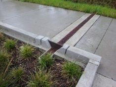 a concrete bench sitting on top of a lush green field