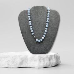 Hand crafted with 8mm aquamarine beads, this necklace radiates soft blue hues of tranquility and serenity. Each bead is hand-knotted using black embroidery floss, adding a touch of contrast and texture.Three silver-plated heart beads are placed together, a little off center, adding a touch of whimsy.The necklace is finished with a silver lobster claw clasp. The 3-inch extender chain provides flexibility in length, allowing you to adjust the necklace to your desired fit.length: 16" + additional 3 Blue Hand Knotted Round Bead Necklaces, Blue Hand-knotted Round Bead Necklaces, Blue Hand-knotted Necklaces, Light Blue Single Strand Necklace With Round Beads, Light Blue Polished Beads Necklace For Gift, Light Blue Gemstone Beads Necklace For Gift, Light Blue Gemstone Beaded Necklace Gift, Silver Hand Knotted Necklace For Gift, Silver Hand-knotted Necklace For Gift