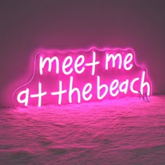 a neon sign that says meet me at the beach