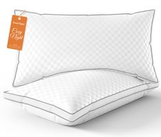 an image of two pillows with price tags on the pillow cover and one is white