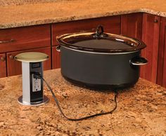 a crock pot sitting on top of a kitchen counter next to an electric outlet