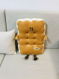 a stuffed toy sitting on top of a couch next to a pillow that says gummy