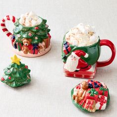 three coffee mugs decorated with christmas decorations and candy canes, sitting on a table