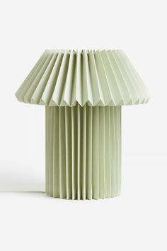 a green table lamp sitting on top of a white floor