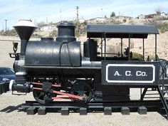 an old fashioned train is parked on the tracks