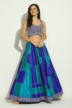 Indigo blue lehenga featuring geometric patchwork embroidery and drawstring closure. Paired with a mirror embroidered padded blouse and a border embroidered sheer dupatta., Fit: Relaxed Sleeveless Blue Sets For Reception, Blue Sleeveless Set For Reception, Blue Sleeveless Sets For Reception, Festive Sets With Geometric Embroidery For Diwali, Festive Diwali Set With Geometric Embroidery, Blue Sleeveless Lehenga For Navratri, Bollywood Blue Sleeveless Sets, Blue Sleeveless Sets With Zari Work, Sleeveless Blue Party Lehenga