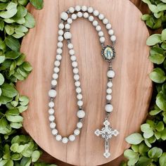 This special Rosary represents Our Lady of Grace, who is the one who intercedes for us with God to obtain His grace. It features pure white tridacna for both the Hail Mary beads and the Our Father Beads, which are offset by silver-plated nuggets along the Rosary. A vintage-style image of Our Lady of Grace is at the center of the Rosary and the crucifix is crafted with white enamel and accented with rhinestones. White Pearl Jewelry With Silver Beads, White Gemstone Beads Jewelry For Wedding, Adjustable White Rosary With 108 Beads, White 108 Beads Jewelry As A Gift, White Pearl Jewelry With Gemstone Beads, Adjustable White Spiritual Beads, White Spiritual Beads, White Pearl Necklaces With 8mm Beads, White Pearl Spiritual Rosary