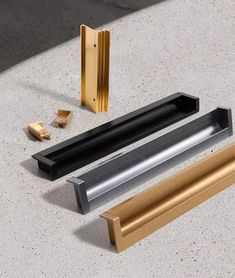 three different types of gold and silver items on a table with one metal object in the middle